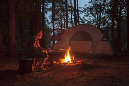 美国阿肯色州一名男子在夜间的森林篝火上做饭