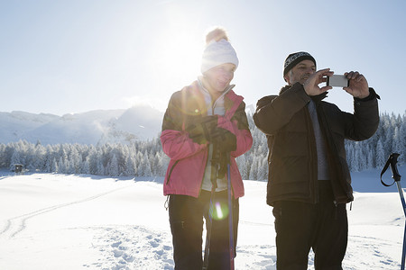 一对老年夫妇在雪地上用智能手机拍照奥地利蒂罗尔的