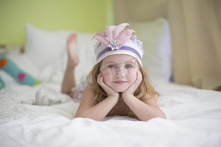 床上戴着公主头饰的年轻女孩的肖像