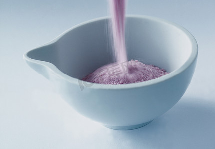 把粉红色的浴盐倒进碗里