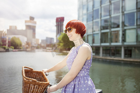 一名女子沿着运河推着自行车英国伦敦东区