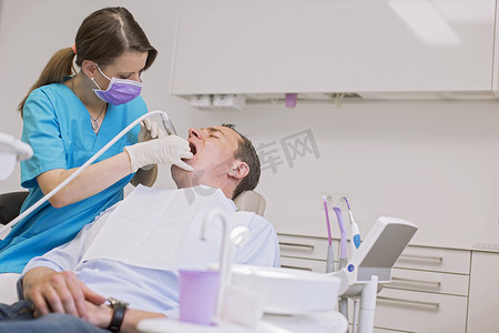牙医为成年男子做牙科检查