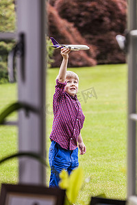 在花园里玩玩具飞机的男孩