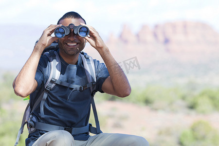 投用摄影照片_美国亚利桑那州塞多纳年轻人用双筒望远镜看的肖像