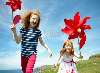前进团队摄影照片_两个女孩带着红色的风车在笑