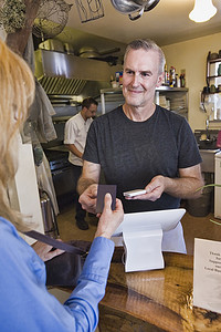 餐饮老板摄影照片_咖啡馆老板在餐厅为顾客服务