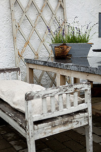 雨中背景摄影照片_雨中露台上的乡村板凳和盆栽