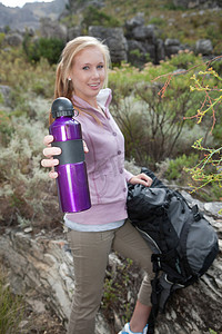饮料瓶摄影照片_年轻女性徒步旅行者拿着饮料瓶的肖像