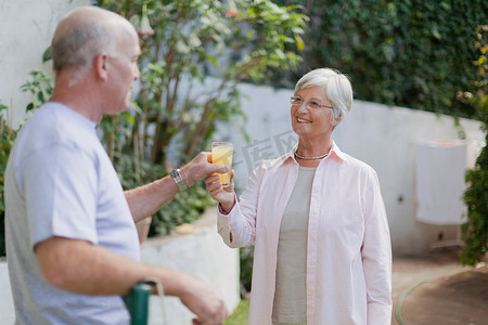 感恩毛笔字摄影照片_年长的夫妇在后院喝果汁
