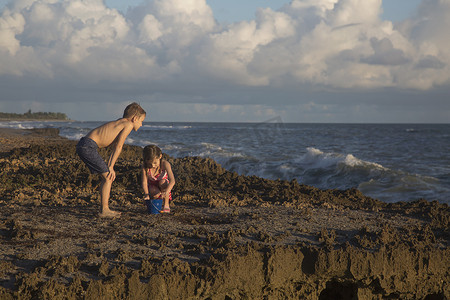 男孩和妹妹在海滩上玩玩具桶吹石保护区美国佛罗里达州朱庇特岛