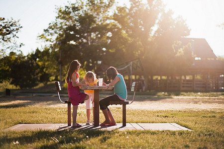 3个女孩坐在公园里画画