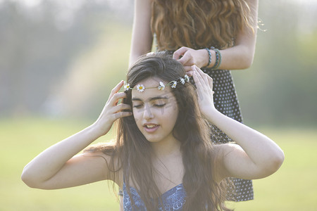 公园里两个十几岁的女孩戴着雏菊链条头饰
