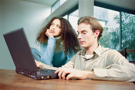男人和女人在家里拿着笔记本电脑
