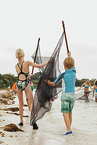 学习如何使用传统渔网的儿童美国佛罗里达州松岛海湾的萨尼贝尔岛