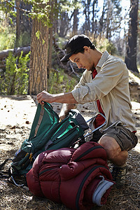 高尔夫球包摄影照片_美国加利福尼亚州洛杉矶森林里的年轻人打开野营装备
