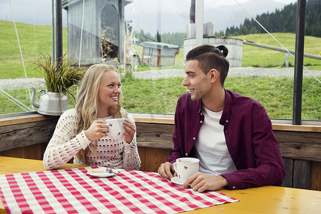 年轻夫妇在咖啡馆边喝咖啡边聊天