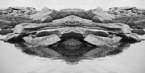对称美摄影照片_岩石和大海的黑白对称细节