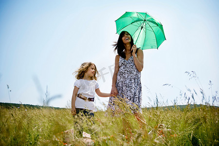 女儿撑着伞的女人