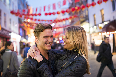 爱情发生摄影照片_英国伦敦唐人街一对浪漫的年轻情侣在夜晚的街头