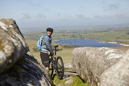 山水人摄影照片_骑自行车的人在露出地面的岩石上骑自行车