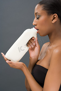 一名妇女喝着一瓶牛奶