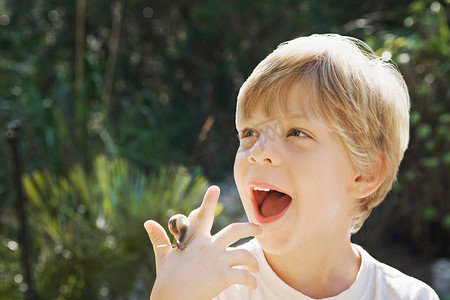 带感的背景摄影照片_一个男孩带着一只蜗牛的头像