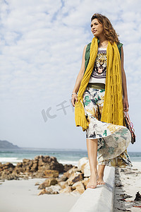 南非开普敦一名年轻女子在海滩上凝视着水泥块