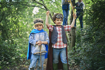 两个男孩盛装打扮在森林里玩耍