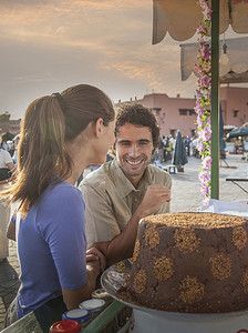 摩洛哥马拉喀什广场市场小吃摊上的一对年轻夫妇