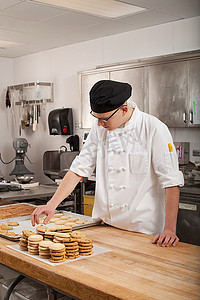 职场年轻人摄影照片_男厨师在商业厨房烘焙饼干