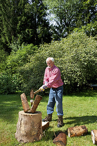 一位老人在花园里砍木头