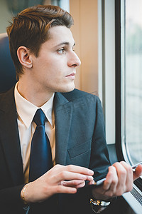 火车上使用数字平板电脑的年轻商人的肖像
