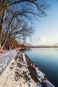 非宁静无以致远摄影照片_白雪覆盖的河岸和宁静的乡村湖泊