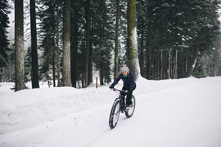 在雪地里骑山地自行车的女子美国加州红杉国家公园