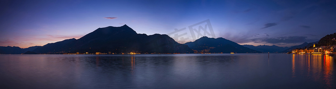 夜湖摄影照片_夜间意大利贝拉吉奥科莫湖上的群山剪影全景