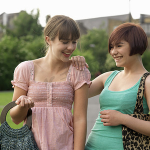 两名年轻女子拎着袋子笑着