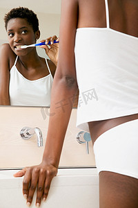 卫生间浴室镜摄影照片_女人刷牙