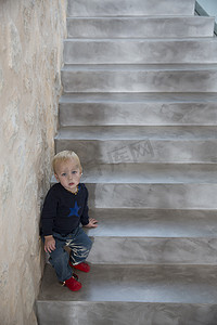 男孩子坐在房子楼梯上的肖像