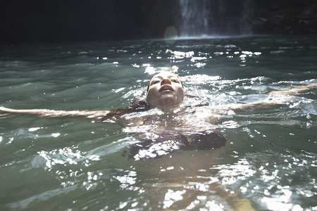 成熟了摄影照片_女子游泳背景是瀑布