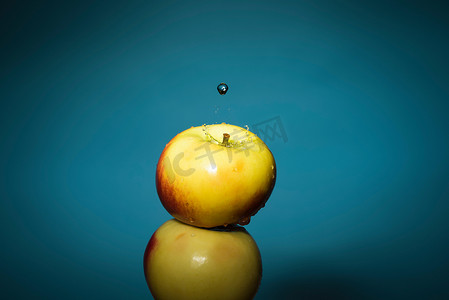 洒水的人摄影照片_洒在苹果上的水的特写