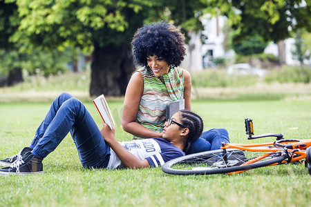 放松技巧摄影照片_男孩和母亲在公园里阅读和放松
