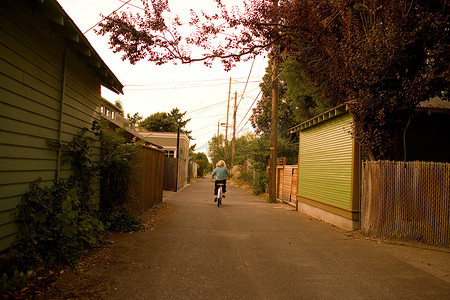 在小巷里骑自行车的男孩