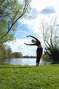 年轻的女舞者在湖边练习