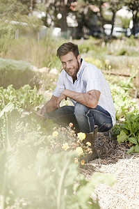 农用地摄影照片_蹲在花园里的成熟男子肖像