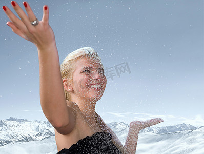 一位年轻女子在飘落的雪地中举起双手