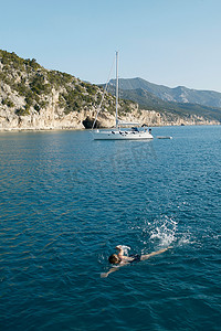水花溅起视频摄影照片_一名女子在游泳背景是船
