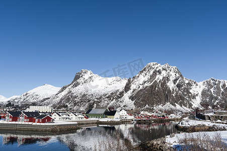 挪威罗福滕群岛斯沃尔沃的滨水房屋和白雪覆盖的山脉