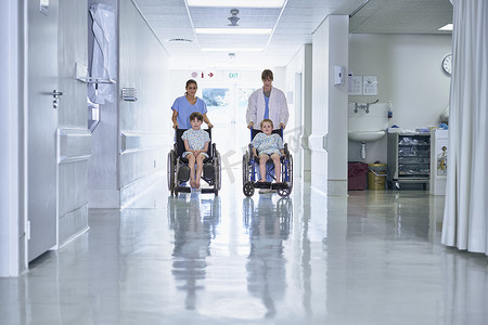 困难儿童摄影照片_医疗秩序在医院儿童病房推着轮椅上的男孩病人