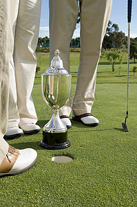 声洞摄影照片_高尔夫球手的腿和奖杯