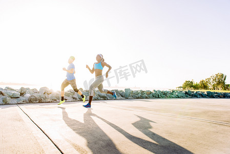 男上衣摄影照片_男人和年轻女人在阳光明媚的海岸上跑步美国加利福尼亚州圣地亚哥市中心